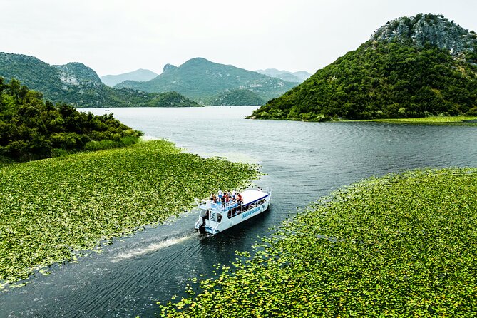Skadar Lake & Crnojevića River: Swimming, Snacks & Wine - Sliding down the river canal, with Vranjina and distant mountain drama