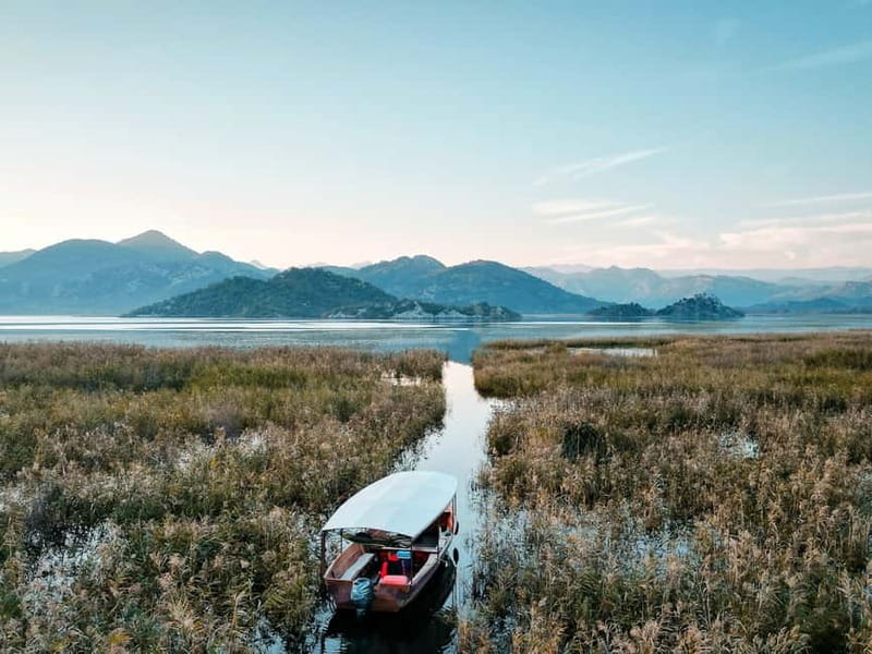 Skadar Lake: Guided Sunset Boat Tour with Wooden Boat & Wine - Through the gorice islands: lotus, reeds, and that narrow-channel feeling
